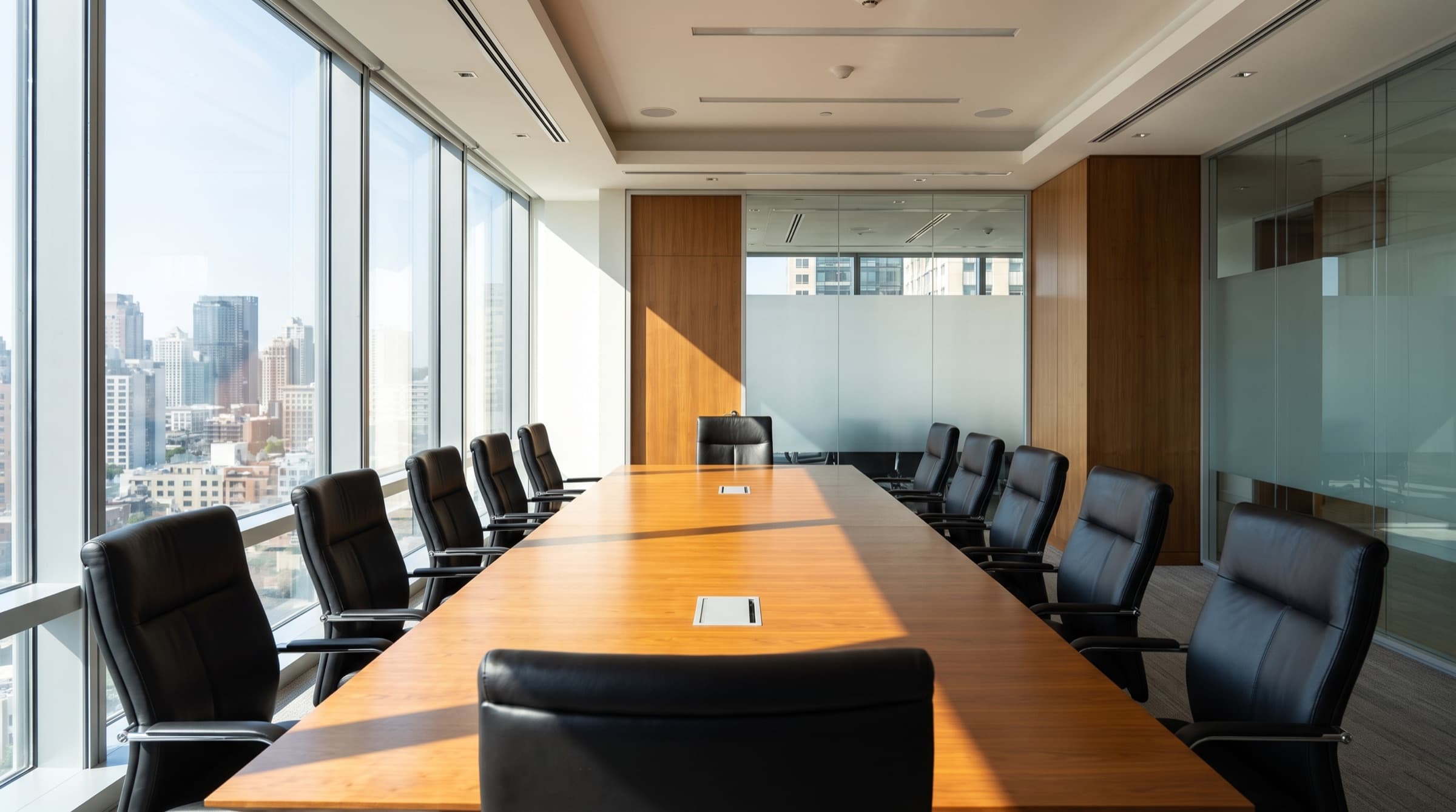 A modern corporate boardroom with a bright daytime city view