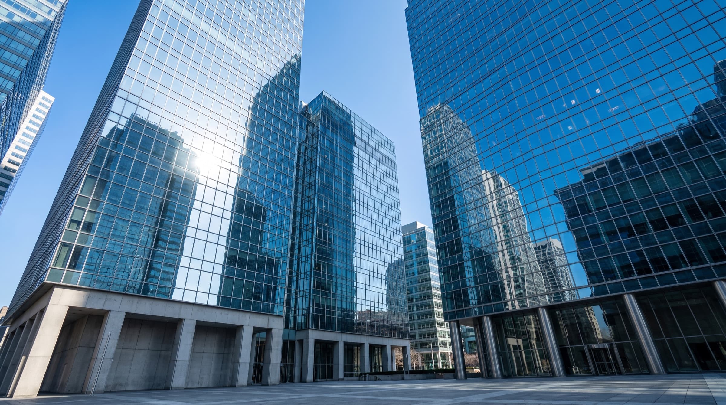 Modern glass corporate towers under a clear daytime sky